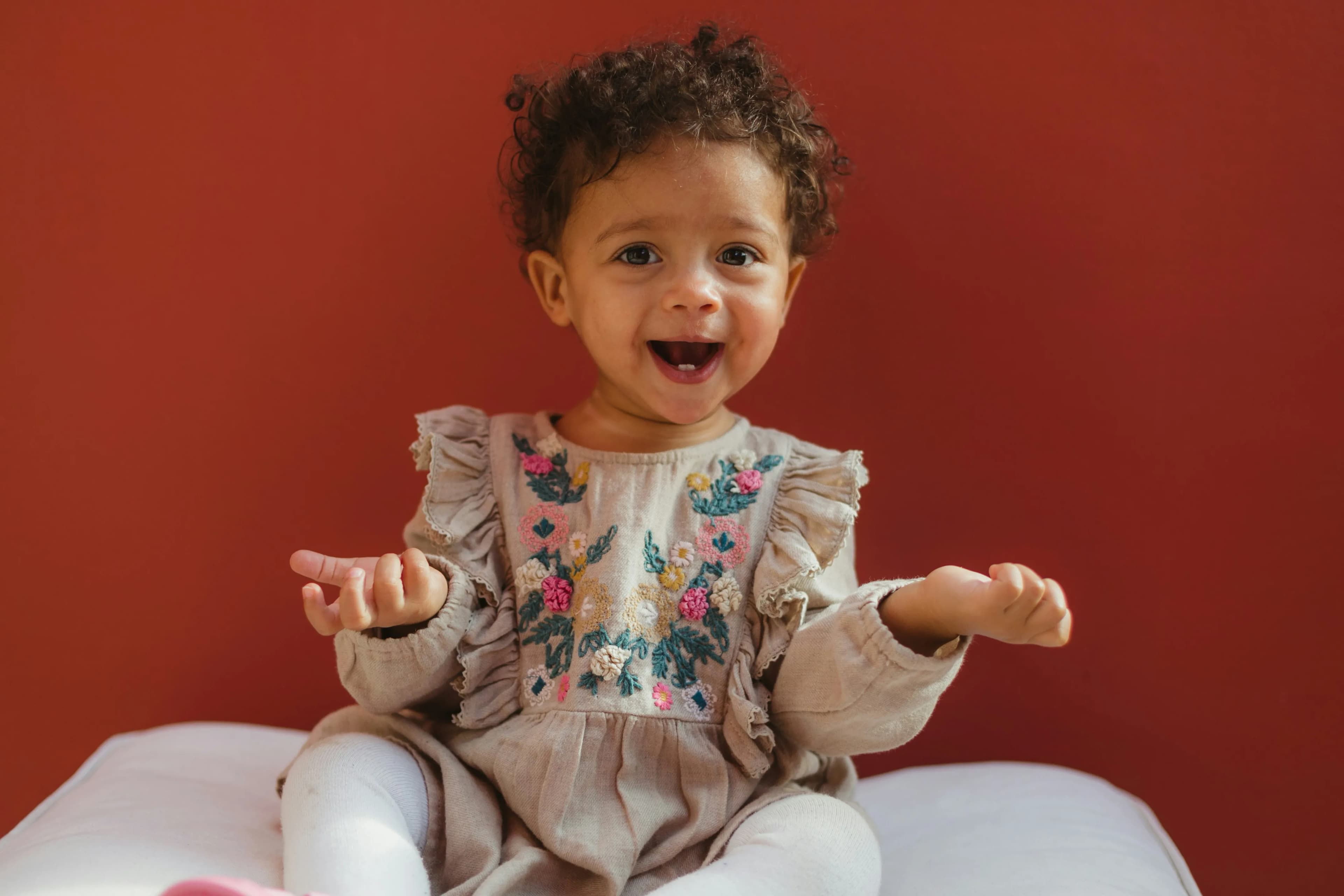 Happy baby girl with a handcrafted gift — Photo by Humphrey M on Unsplash
